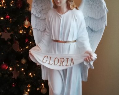 Figurka białego anioła z szarfą z napisem Gloria, z dekoracji świątecznej na drugim piętrze