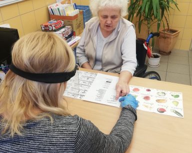 Seniorka rozmawia z neurologopedą przy pomocy tablic do komunikacji alternatywnej