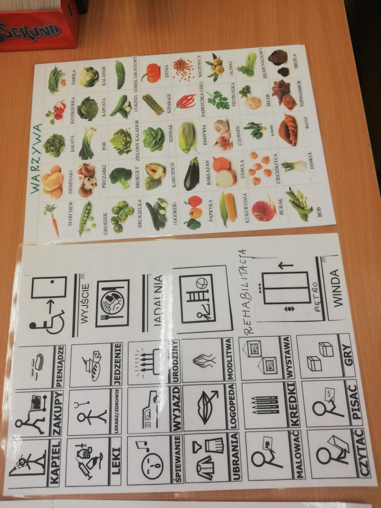 Na stole leżą tablice do komunikacji AAC z symbolami Makatona i podpisanymi obrazkami warzyw
