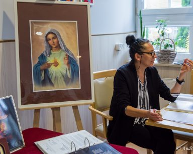 Terapeutka Magdalena Poraj-Górska prowadzi zajęcia. Obok portrety Matki Boskiej.
