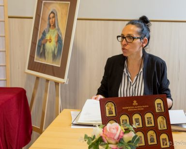 Terapeutka Magdalena Poraj-Górska prowadzi zajęcia. Na stole kolekcja małych obrazów Matki Boskiej w drewnianej ramie.