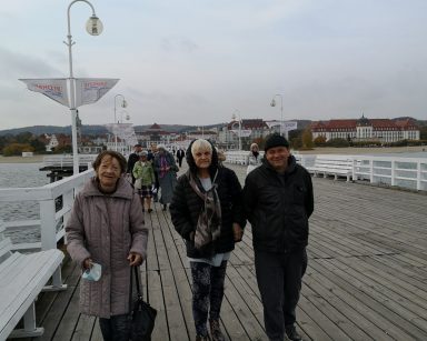 Molo w Sopocie. Troje seniorów na spacerze. Mają ciepłe kurtki.