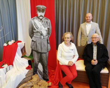 Przy tekturowej postaci Piłsudskiego dwoje seniorów, kierownik Arkadiusz Wanat. Dekoracja z okazji Święta Niepodległości.