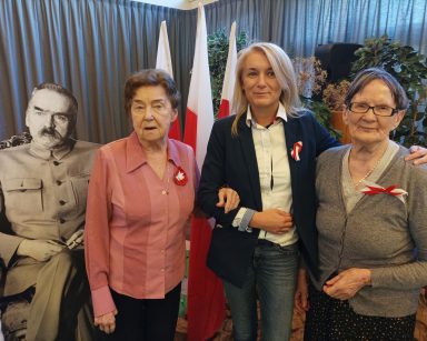 Przy tekturowej postaci Piłsudskiego dwie seniorki, kierowniczka Ilona Gajewska. Dekoracja z okazji Święta Niepodległości.