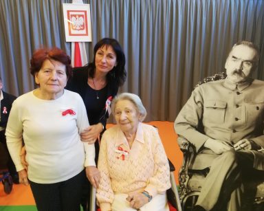 Przy tekturowej postaci Piłsudskiego dwie seniorki i terapeutka Ania Rzepczyńska. Dekoracja z okazji Święta Niepodległości.