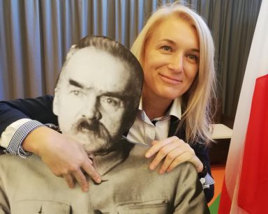 Kierowniczka Ilona Gajewska obejmuje ręką tekturową postać Piłsudskiego. Dekoracja z okazji Święta Niepodległości.