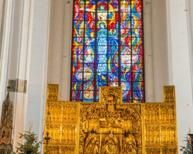 Bazylika Mariacka. Złoty ołtarz. Za nim wielkie okno z kolorowym witrażem.