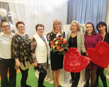 Zdjęcie grupowe. W centrum stoi dyrektorka Agnieszka Cysewska z bukietem kwiatów. Obok niej pracownicy DPS.