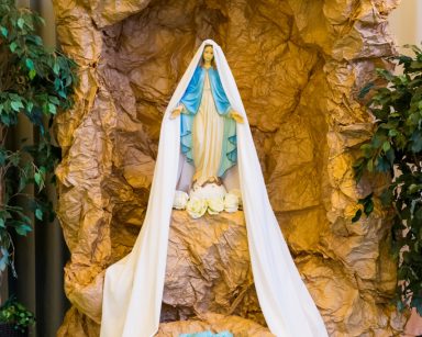 Sala. Skalna grota zrobiona z brązowego papieru. W środku figurka Matki Boskiej. Ma założony długi biały welon.