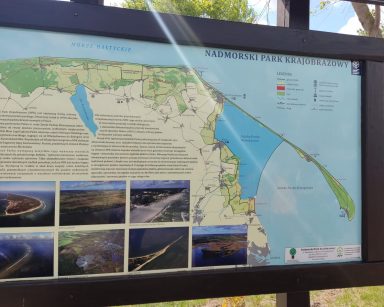 Na świeżym powietrzu tablica z mapą morza i nabrzeża. Napis nadmorski park krajobrazowy.