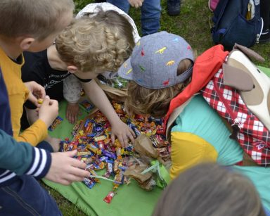 Dzieci z przedszkola Bursztynowy Domek w Gdańsku rozpakowują prezent. To kolorowe cukierki.