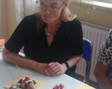Warsztaty kulinarne. Przy stole siedzi dyrektor Agnieszka Cysewska. Na blacie owoce.