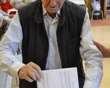 Sala. Senior wrzuca do urny kartę do głosowania na Budżet Obywatelski.