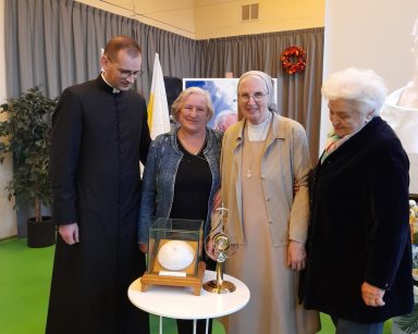 Sala. Ksiądz Tomasz Kosewski, siostra zakonna i dwie seniorki pozują do wspólnego zdjęcia.