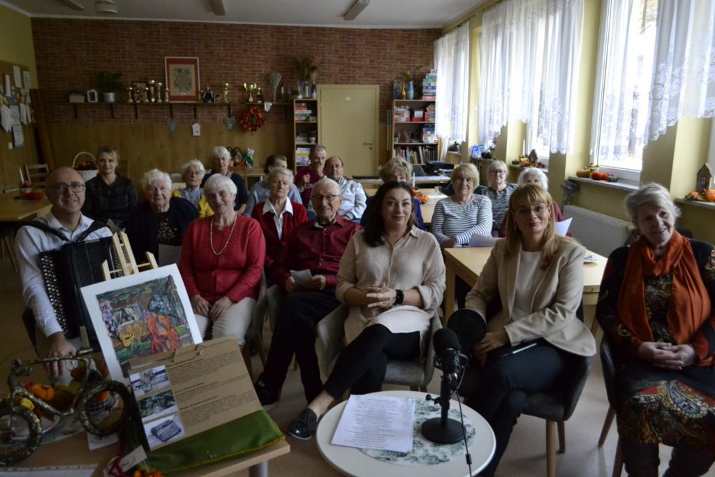 Sala. Grupa ludzi siedzi razem.