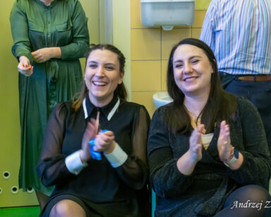 Na pierwszym planie terapeutki Martyna Józefczyk i Paulina Winczura. Śmieją się, biją brawo.