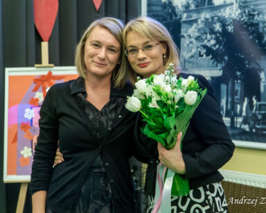 Sala. Dyrektorka Agnieszka Cysewska i jej zastępczyni Ilona Gajewska pozują do zdjęcia. Dyrektorka trzyma bukiet kwiatów.