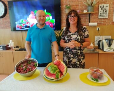 Sala. Kierownik Arkadiusz Wanat i dietetyczka Karolina Gorzkiewicz stoją przy stole z owocami.