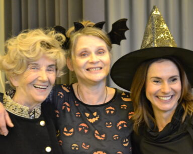 Zbliżenie. Trzy uśmiechnięte kobiety pozują do zdjęcia. Panie maja ozdoby Halloween na głowie.