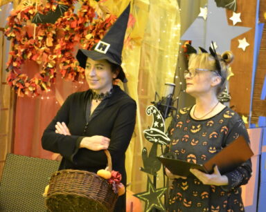 Zbliżenie. Dwie kobiety ubrane w stroje Halloween stoją na scenie.