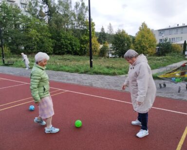 Pogodny dzień. Boisko. Dwie kobiety kopią piłkę.
