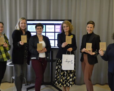 Grupa sześciu kobiet pozuje do zdjęcia. Wyciąga przed siebie książeczkę z napisem Brain Health Polska.