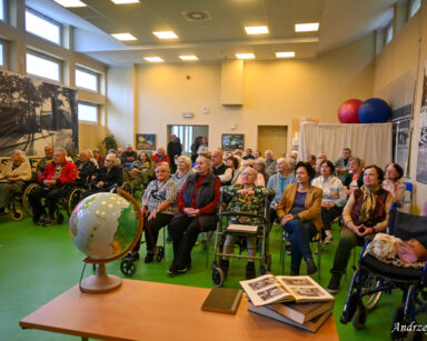 Sala. Na sali pełno seniorów, w drzwiach opiekunowie DPS. Wszyscy oglądają co dziej się na scenie.