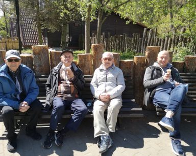 Pogodny dzień. Gdańskie ZOO. Kierownik Arkadiusz Wanat i trzej seniorzy odpoczywają na ławce.