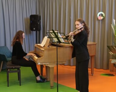 Zbliżenie. Na scenie przy fortepianie siedzi kobieta, obok przy mikrofonie gra młoda kobieta na skrzypcach.